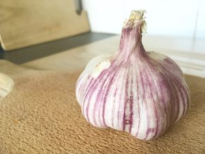 purple garlic on cutting board