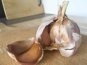 purple garlic on cutting board with cloves removed