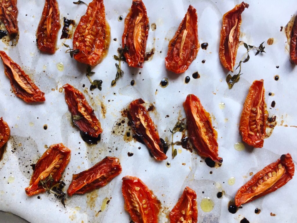 semi-dried tomatoes with thyme and balsamic on baking sheet