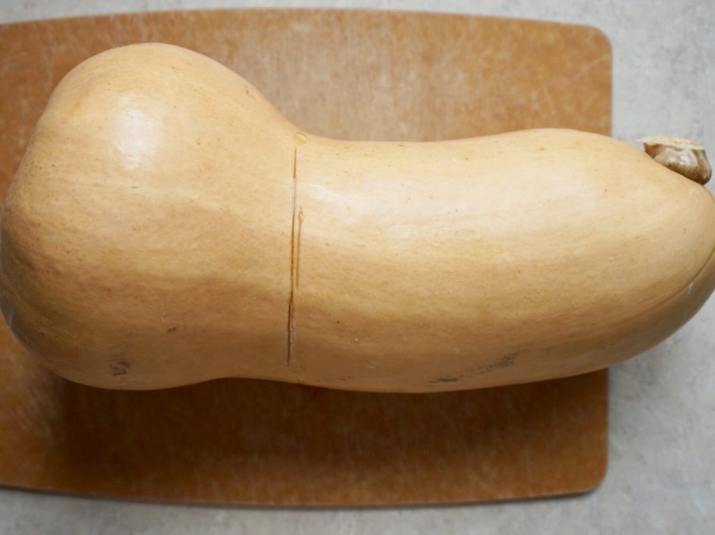 Butternut squash on cutting board with line cut in neck