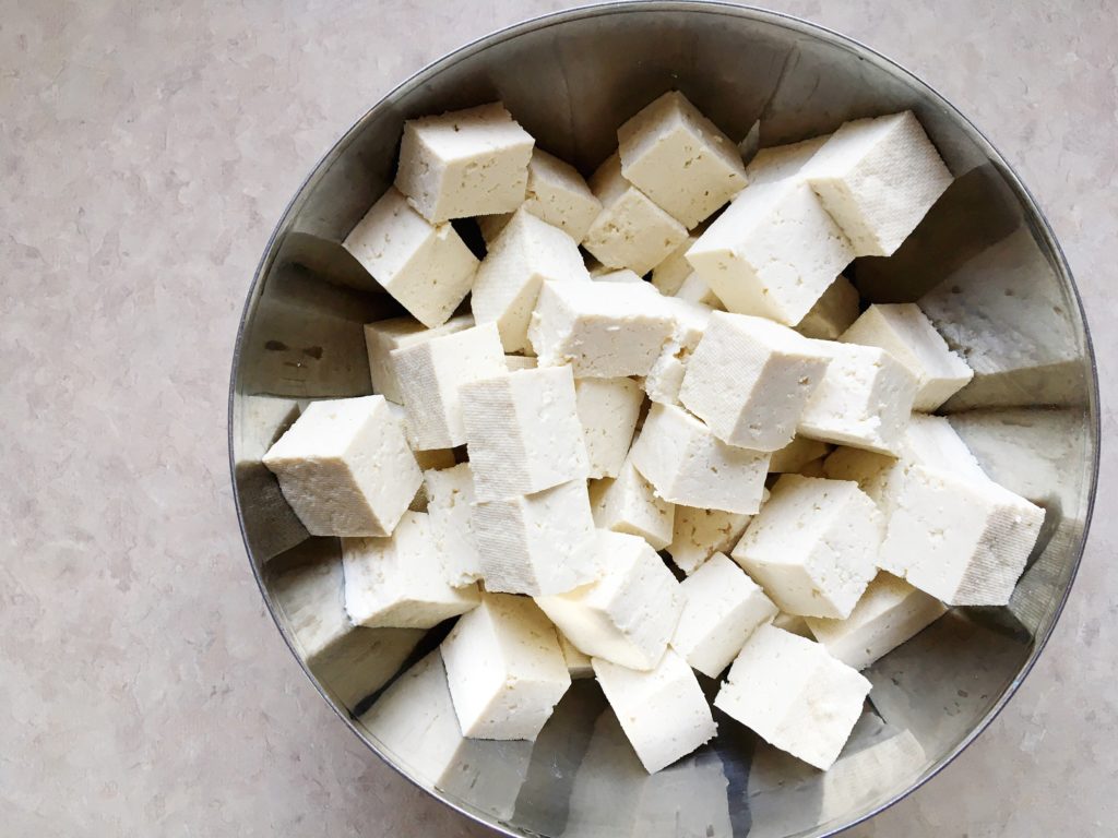 Cubes of tofu in stainless steel bowl
