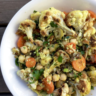 moroccan-spiced roasted cauliflower and carrot salad with chickpeas and couscous in deep plate