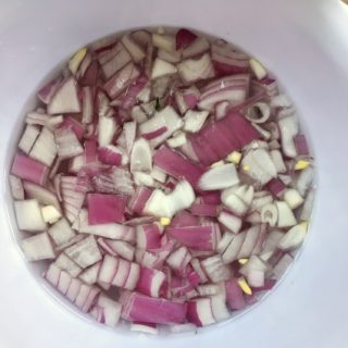 diced red onions in bowl of water