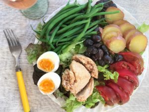 salade niçoise with green beans, tomatoes, egg, tuna, tomatoes, olives, and potatoes