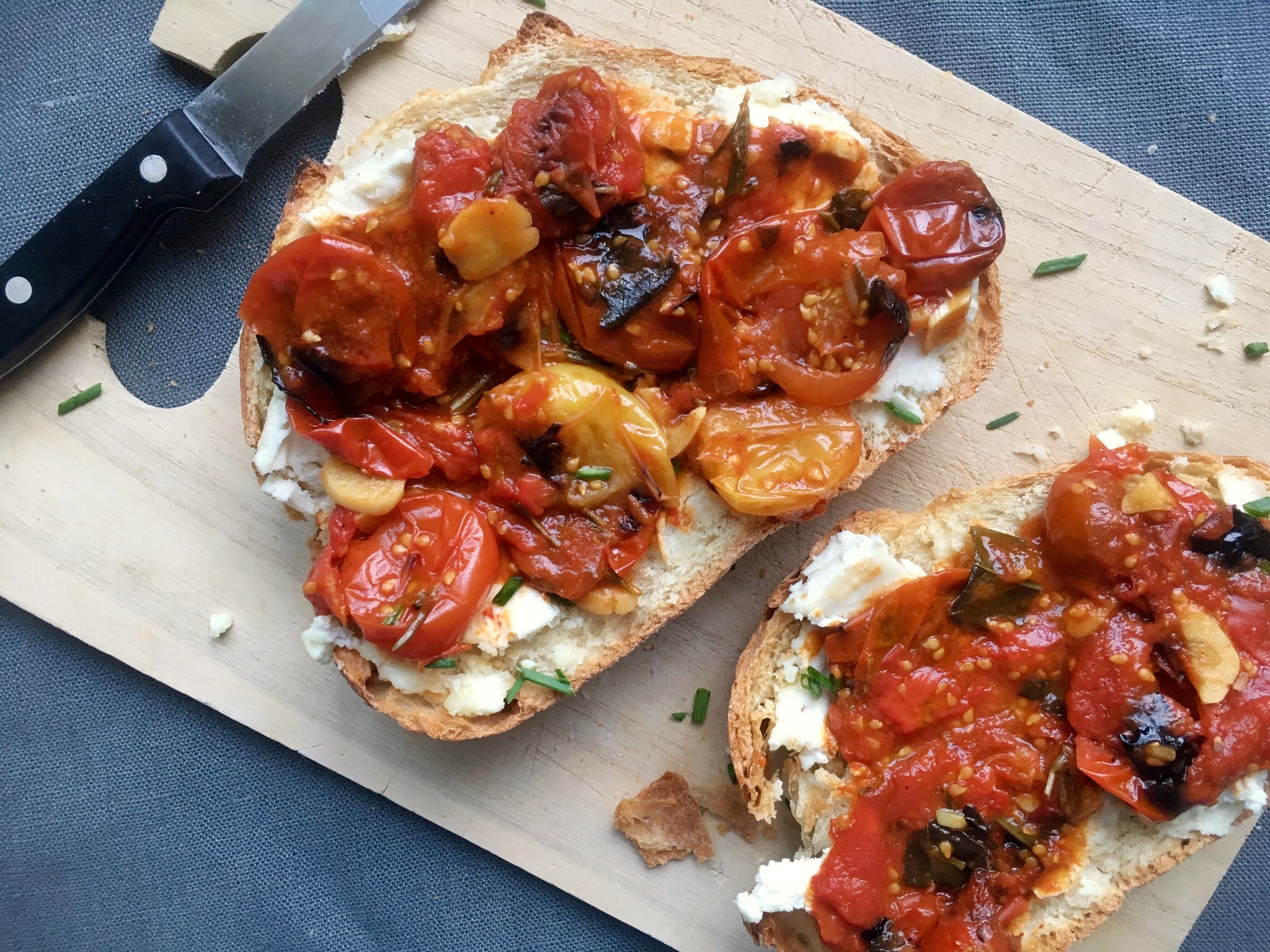 Goat cheese toasts with herbed cherry tomato compote rustic style on board