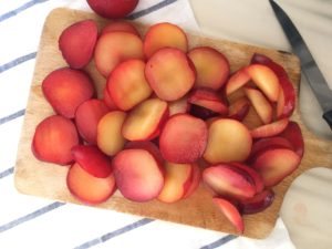 Sliced plums on cutting board
