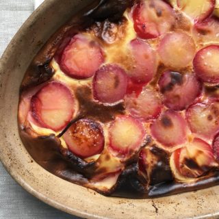 Plum clafoutis in rustic French gratin dish