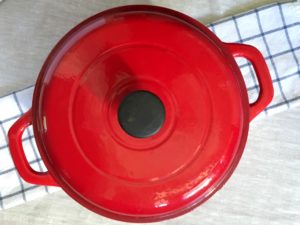 Red Tramontana 6.5 quart Dutch oven on checkered dishtowel and linen tablecloth
