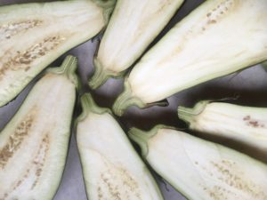The tops of three eggplants, halved lengthwise