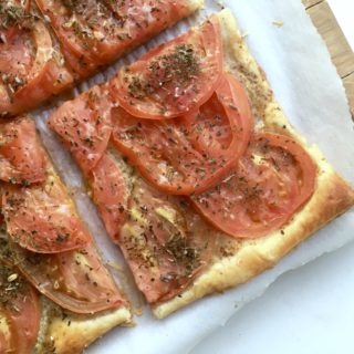 Tomato tart with dijon and herbes de provence on cutting board