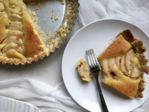 slice of pear and almond tart from journal des femmes, on a white plate with a silver fork