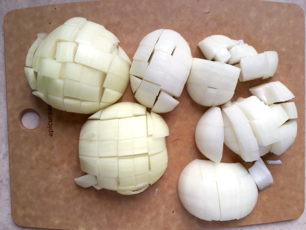 chopped yellow onions on epicurean cutting board