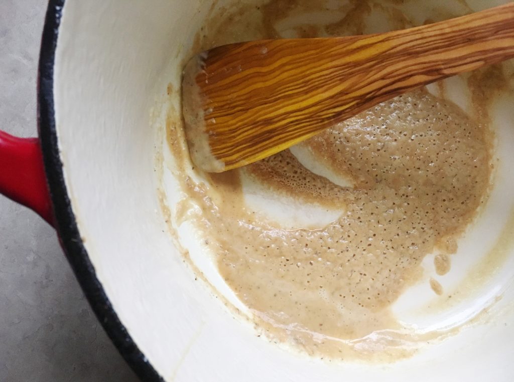 Roux and olive wood spoon in dutch oven