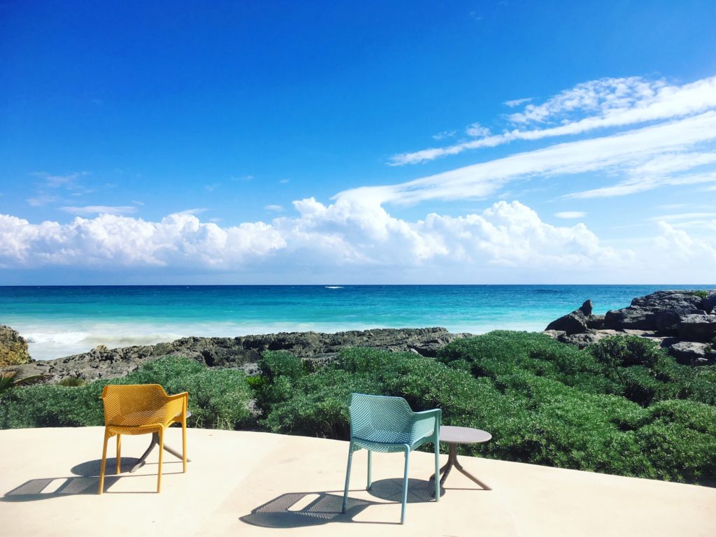 Zamas Tulum back patio with yellow and blue chairs and ocean view
