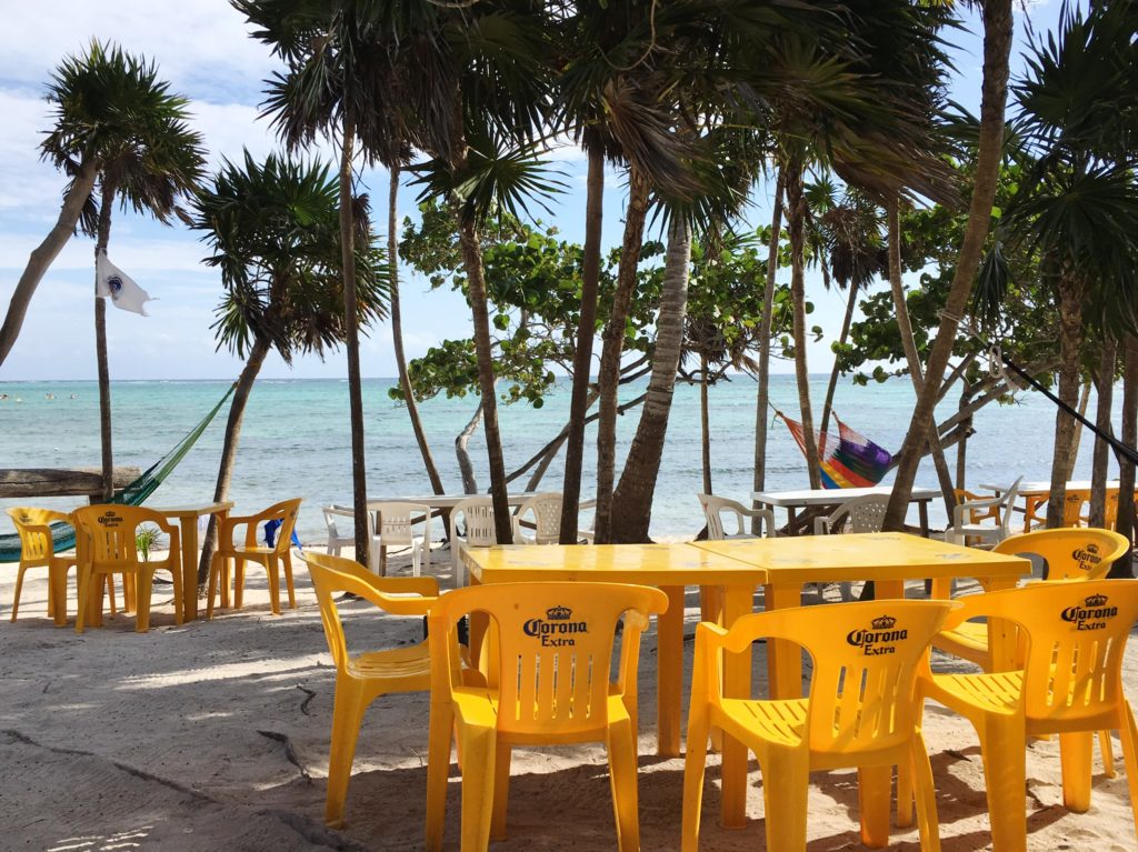 Yellow tables on beach at Chamico's in Tulum