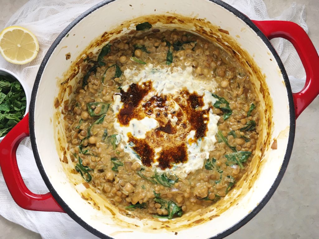 Yogurt soup with lentils, barley, and mint from Alice Hart, ready to serve in red dutch oven with extra yogurt on top