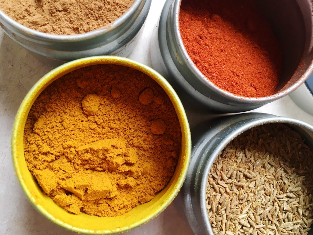 Turmeric, cumin, paprika, and cinnamon in spice jars