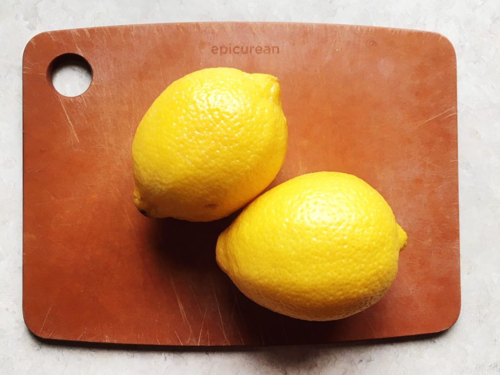 Two lemons on epicurean cutting board