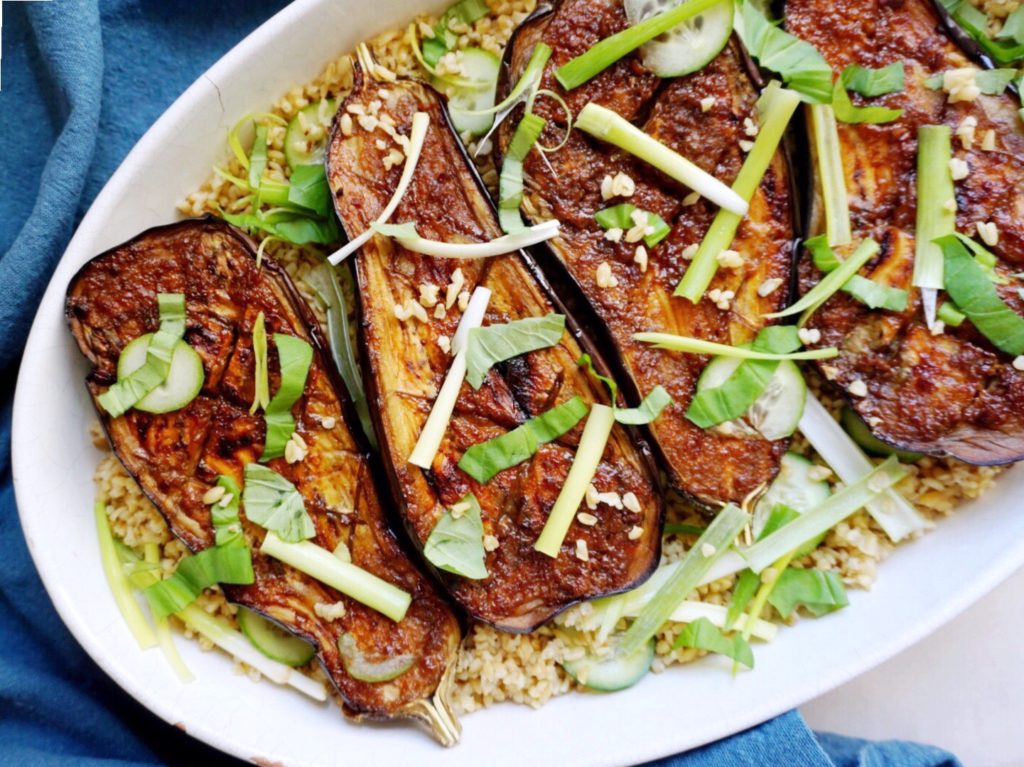 Meaty eggplant with soy-miso glaze in white dish atop grains