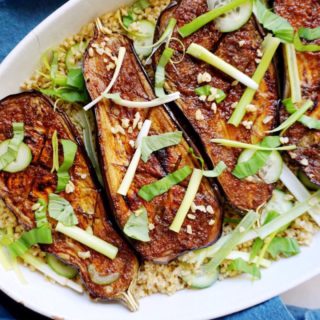 Meaty eggplant with soy-miso glaze in white dish atop grains