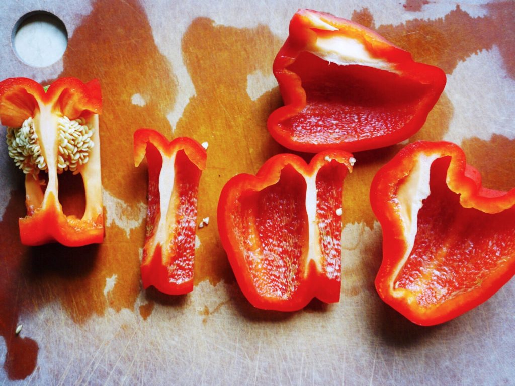 Four slices of bell pepper plus core on cutting board