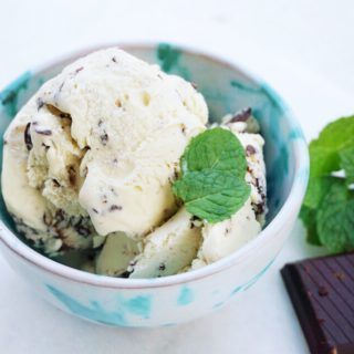 Mint chocolate chip ice cream in Pugliese ceramic bowl with square of Valrhona chocolate and mint leaves on the side