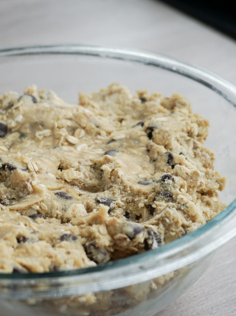cookie dough for Mom's oatmeal chocolate chip cookies with walnuts in glass bowl