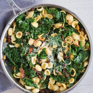 Orecchiette with Kale, Bacon, and Sun-dried Tomatoes in pan with grey tea towel