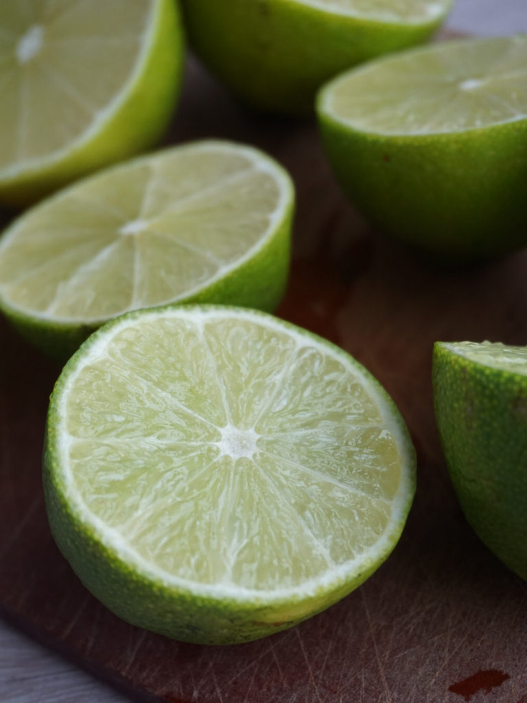 Halved limes on cutting board for Cranberry Lime Curd Pie from Bon Appetit