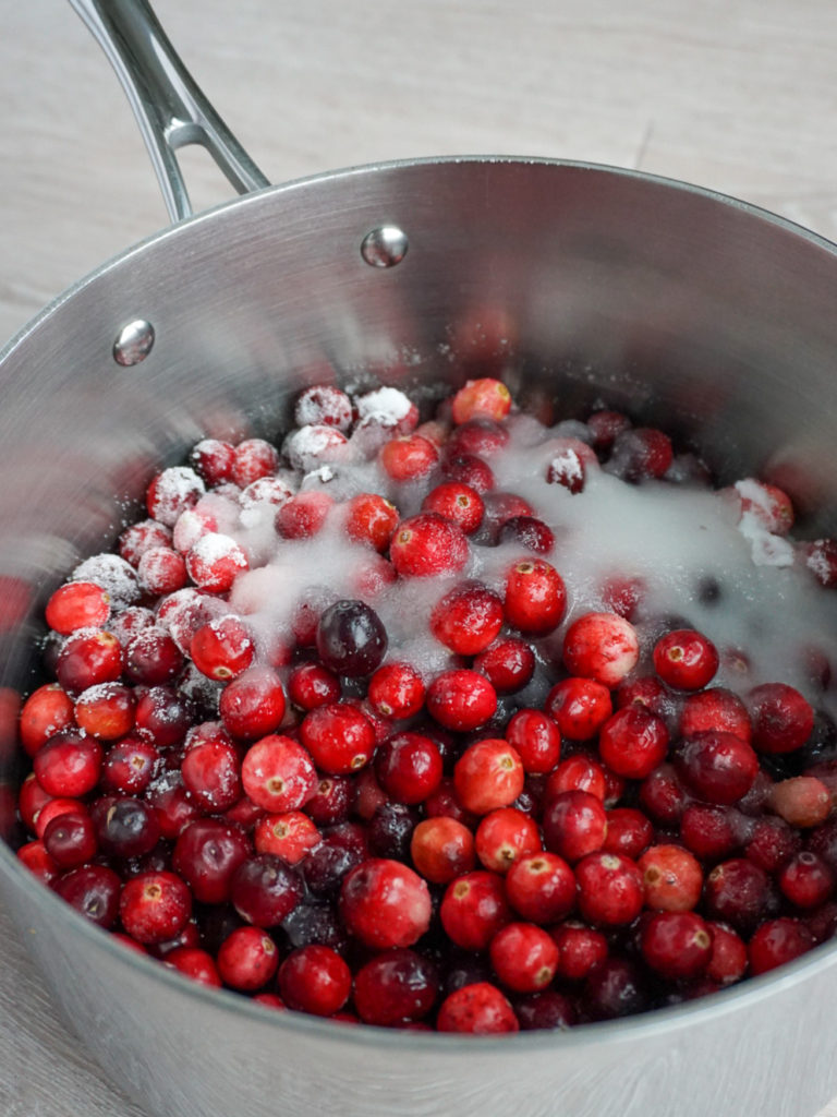 Cranberries and sugar in pot for Cranberry Lime Curd Pie from Bon Appetit