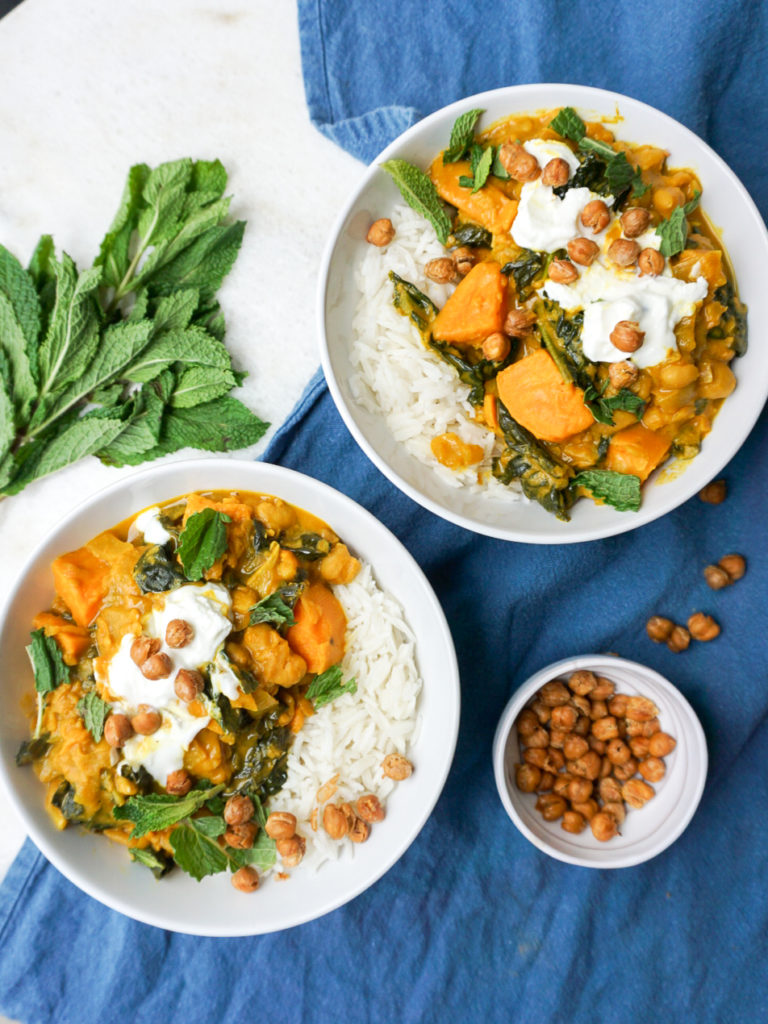 Spiced Chickpea Stew with Coconut and Sweet Potato in bowls on blue background