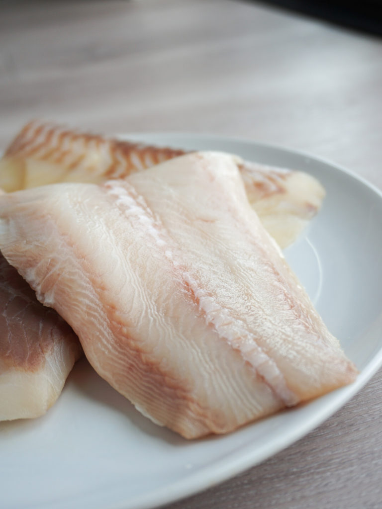 Three pieces of Alaskan halibut on plate