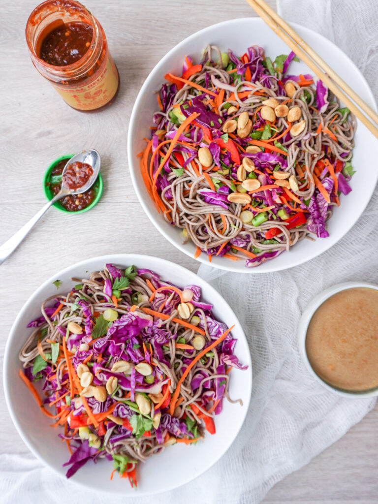 Two bowls of easy Asian noodle salad with peanut sauce on the side